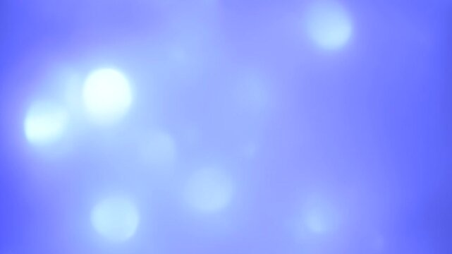 Abstract white and blue lights and circles of bokeh glittering and slowly moving 