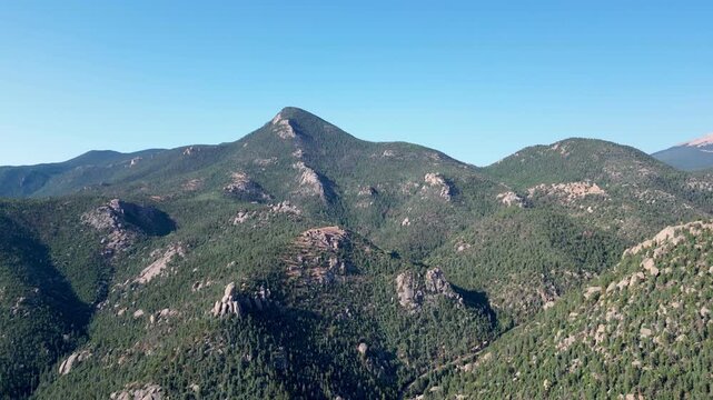 Moving aerial mountain views against clear blue sky