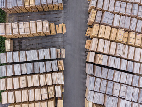 Aerial view of organized stacks of timber and lumber in a wood storage yard, showcasing industrial logistics and sustainable forestry materials in Bruneck, Trentino-Alto AdigeS, Italy.