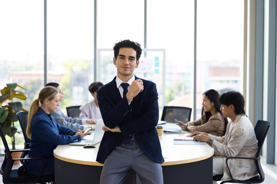 Businessman Standing In Corporate Office. working in office workplace. Young middle-aged Hispanic smiling handsome businessman entrepreneur looking at camera