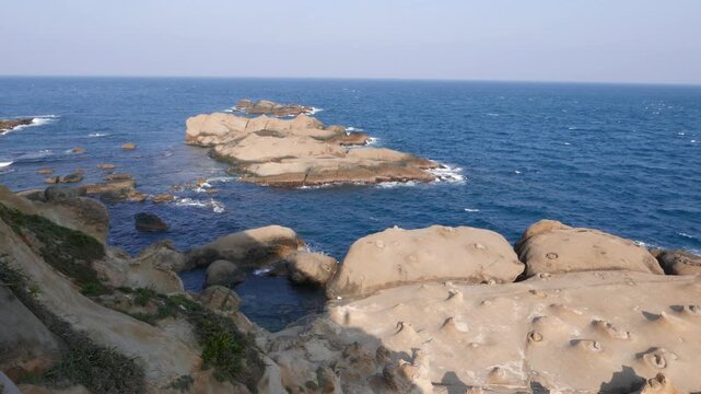 Polished rocky shore, odd shelf rock surface, evening sunlight, Yehliu Geopark area. Sea cape ridge created by volcanic and salted waters work. Yeh-Liou is promontory on north coast of Taiwan