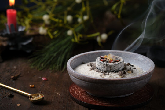 Frankincense, resins and dried herbs burning on glowing charcoal - incense ritual on Yule