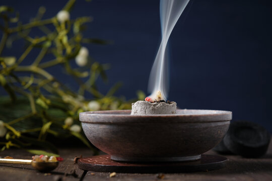 Frankincense, resins and dried herbs burning on glowing charcoal - incense ritual on Yule