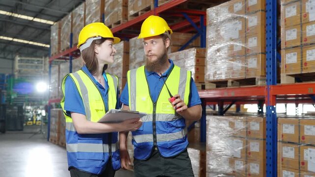 Workers inspect inventory in a warehouse while checking stock levels and discussing tasks