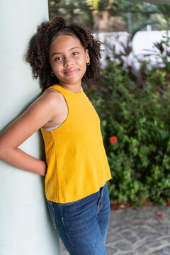 Smiling african american teenage girl leaning outdoors