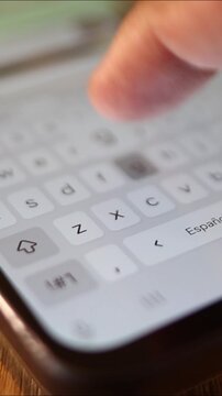 Person typing text message on smartphone touchscreen keyboard. Close up of finger using mobile phone app for communication