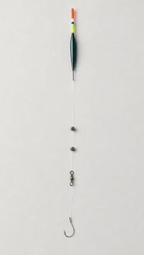 Fishing gear setup featuring a bobber, sinkers, swivel, and hook arranged vertically against a neutral background for clear visibility and identification