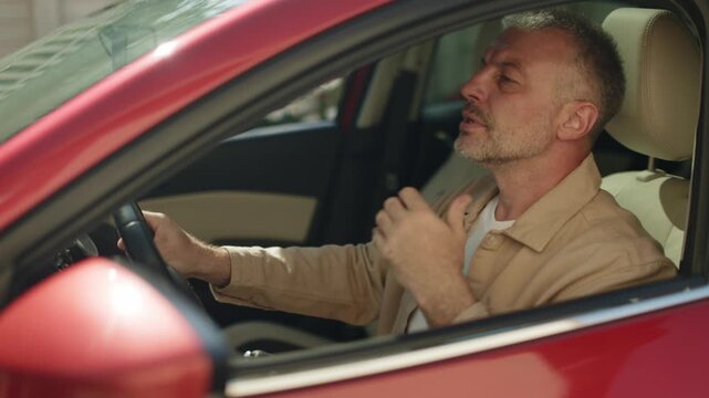 Bored man in in car complaining in traffic and resting chin on hand