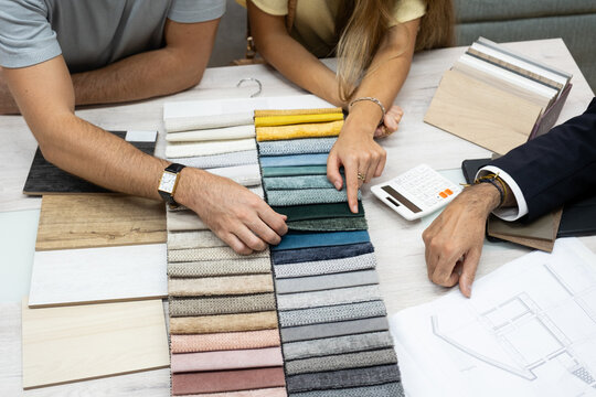 Interior designer presenting various material options to a couple planning home renovation