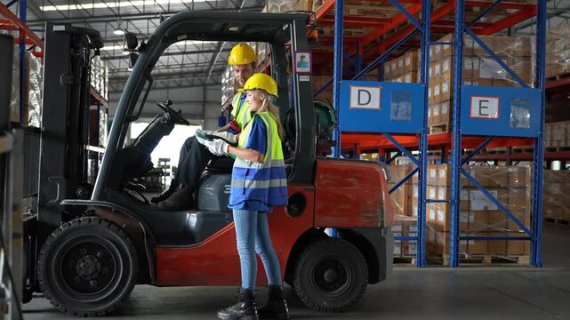 Workers discuss safety procedures in a warehouse with a forklift in a busy environment