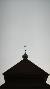 A serene mosque silhouette at sunset with a vibrant yellow sun
