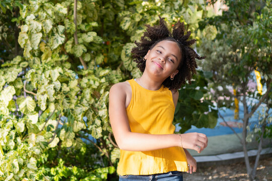 Young girl with afro hair smiling outdoors in nature