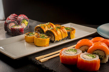 Assorted gourmet sushi rolls served on ceramic plate with chopsticks © Ilias
