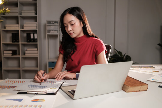 Young woman analyzing business data working late at night