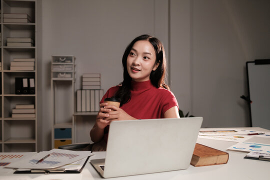 Young Asian woman working late, planning business strategy