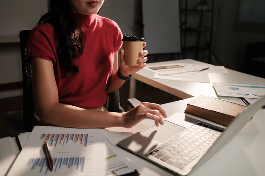 Woman working late in office drinking coffee