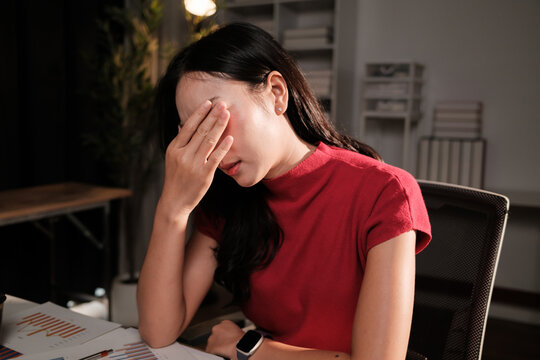 Stressed businesswoman suffering headache working late at office desk