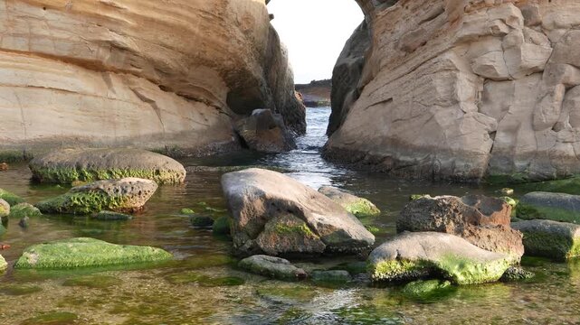 Gap between two huge stone, washed by salted water, Yehliu Geopark. Water pool created by sea surf and weathering. Evening time, soft lighting. Geological Park details, sea cape nature views.