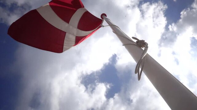 Hirtshals, Denmark A Danish flag flies on a flagpole.