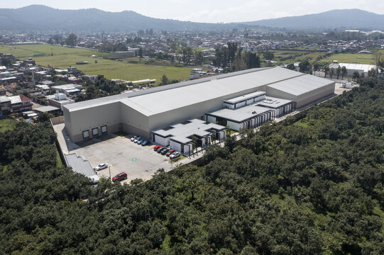 Aerial view of an avocado packing house surrounded by orchards and urban landscape in Uruapan, Michoacan, Mexico.