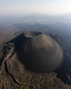 Aerial view of Paricutin Volcano, a cinder cone volcano with a prominent crater, surrounded by volcanic landscape and sparse vegetation in Paricutin, Michoacan, Mexico.