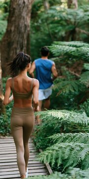 Couple running on a forest boardwalk background with athletic activewear for wellness banner and fitness design
