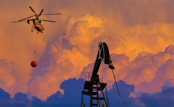 A helicopter attempting to extinguish a fire at an industrial facility.