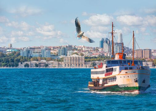 Sea voyage with old ferry (steamboat) in the Bosporus - Dolmabahce Palace  seen from the Bosphorus - Dolmabahce palace against coastal cityscape with modern buildings under cloudy sky - Istanbul