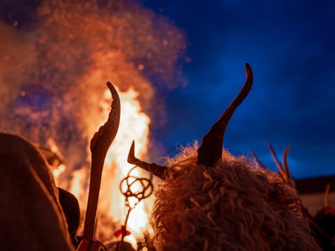 Bus&oacute; figures in horned costumes gathered around a bonfire