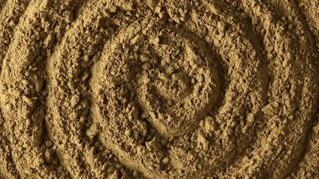 Close-up hojicha powder rotates in circular motion and reveals roasted texture for beverage, food and background concepts.