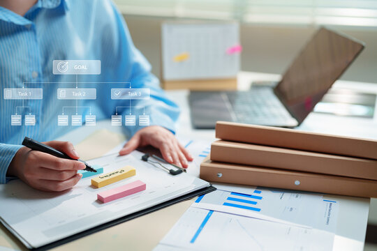 Business professional planning goals, tasks and workflow with sticky notes, reports and laptop. project management, strategic planning, productivity, business process and goal setting