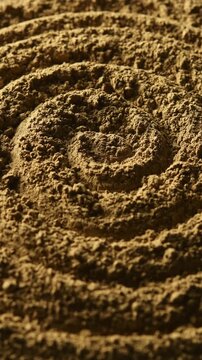Light gradually reveals spiral hojicha powder texture in close up for tea, food, abstract background and ingredient concepts.