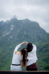 Naklejka premium Two young women enjoying mountain scenery during a relaxing vacation