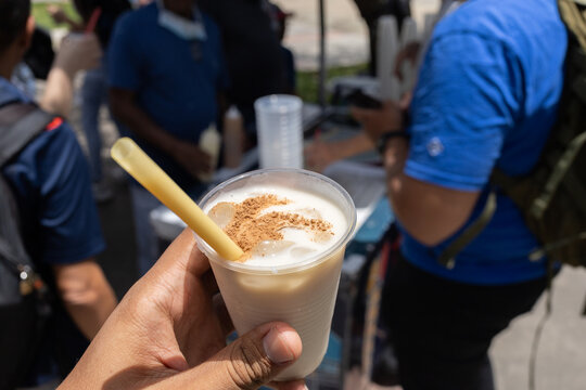 Traditional Venezuelan Chicha Rice Drink with Cinnamon and Condensed Milk Held in Hand at Outdoor Street Stand
