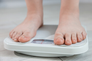Fototapeta premium Overweight woman on scale at home, closeup