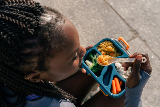 Eating Lunch From a Colorful Lunchbox Outdoors in the City