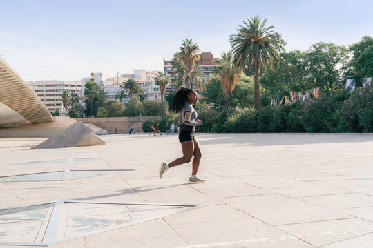 Woman Runs in Outdoor Park During Afternoon in Urban Setting