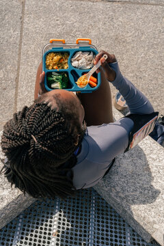Anonymous woman enjoying healthy lunch in the city after workout