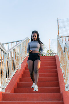 Woman Jogs Down Stairs in Workout Clothes During the Day