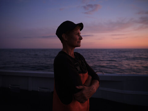 The captain of a fishing boat looking to the sea during evening hours