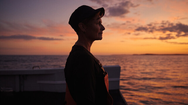 The captain of a fishing boat looking to the sea during evening hours