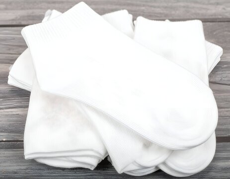 Folded white socks on wood surface.