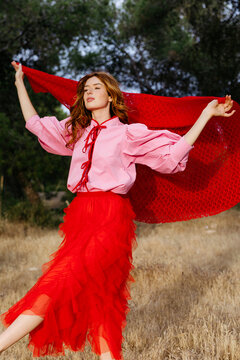 Woman posing outdoor with red skirt and pink shirt