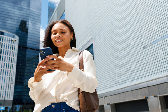 Woman using smartphone in urban downtown business district