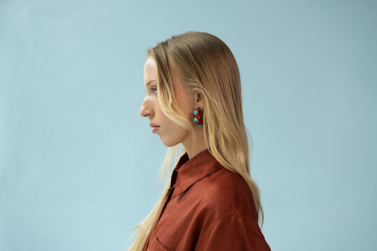 Side Profile Portrait of Blonde Female Model in Terracotta Shirt 