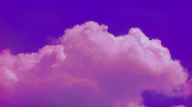 Vibrant time lapse of cotton pink clouds moving across a deep cobalt blue sky