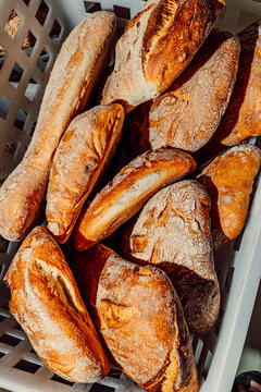 Basket filled with various fresh artisan bread loaves.