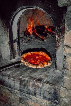 Traditional Neapolitan pizza baking in a wood fired oven