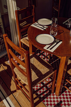 Empty wooden restaurant table and chairs set for dinner outdoors