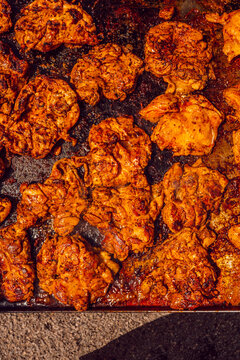 Large tray of seasoned grilled chicken pieces close up